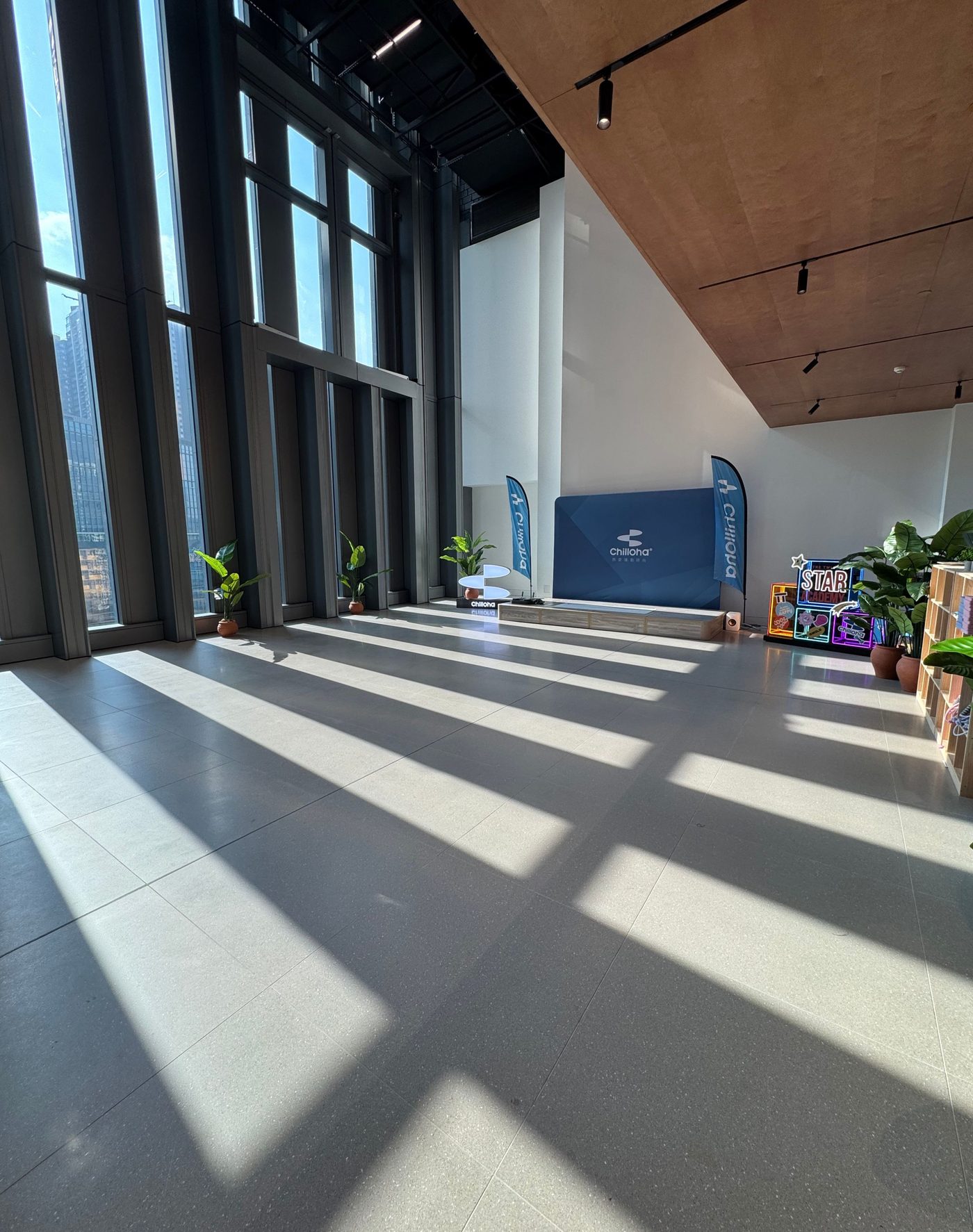 The 9/F TT SITE floor — double-height glass and lounge corner