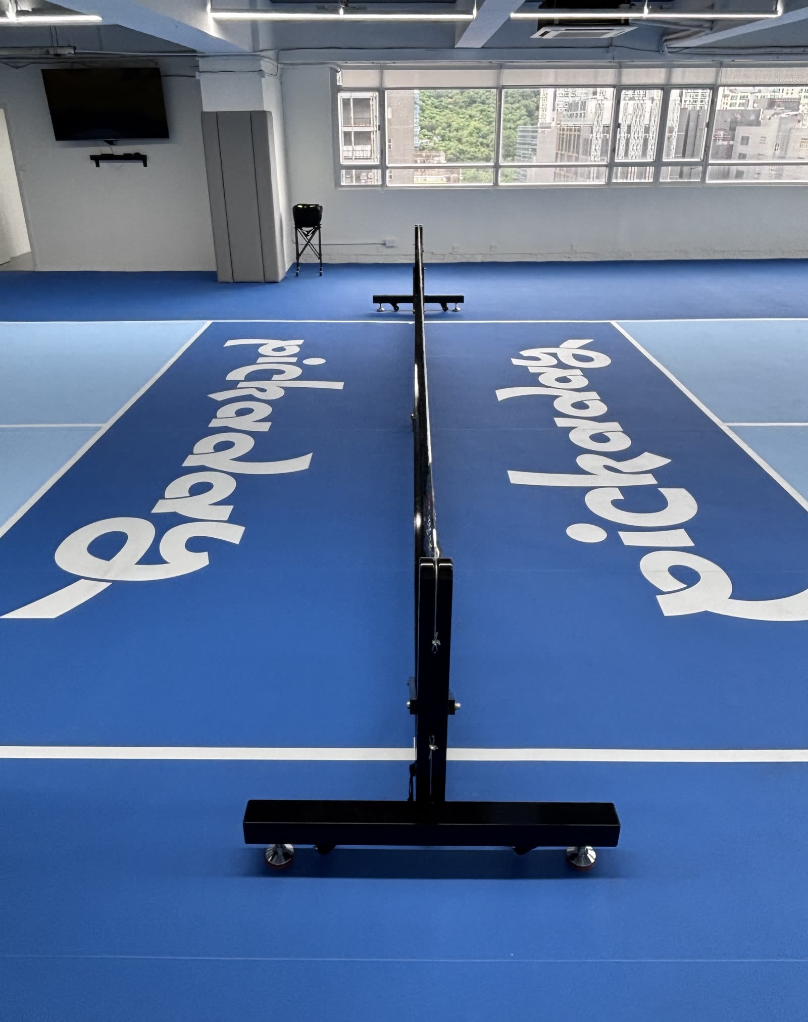Tournament-grade Arronax net on the fresh blue court