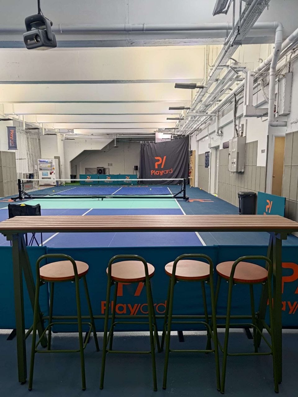 Bar table and stools looking straight down the court