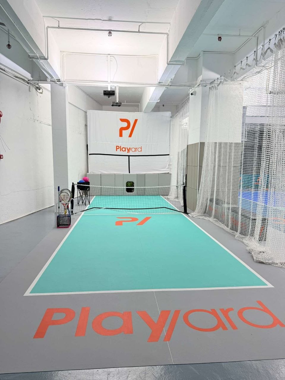 The smaller netted training court and ball-machine lane