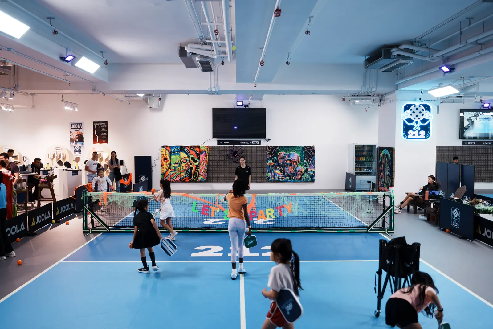 Children playing pickleball under party decorations during a private party at 212HK