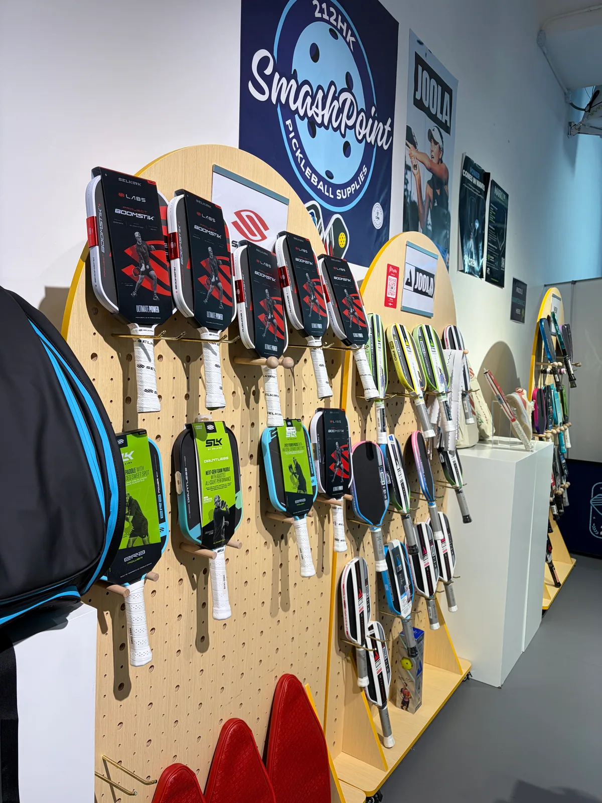 A full wall of Selkirk and JOOLA paddles inside the SmashPoint pro shop