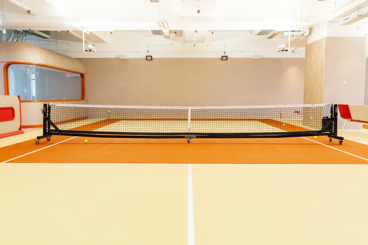 Net-height view down the centre of the terracotta court
