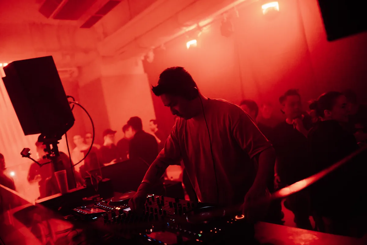 DJ set under red light at a glow-in-the-dark pickleball night